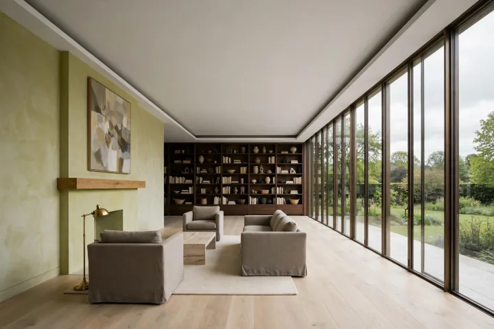 Open-plan living room with pale oak floor, lime plaster fireplace and a full-height glazed wall